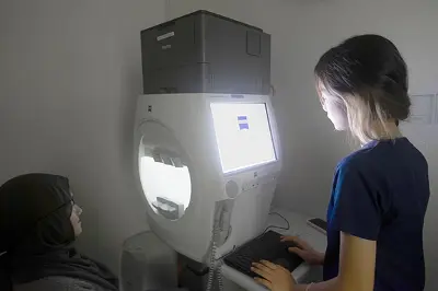 Optometry student operating an automated visual field analyzer